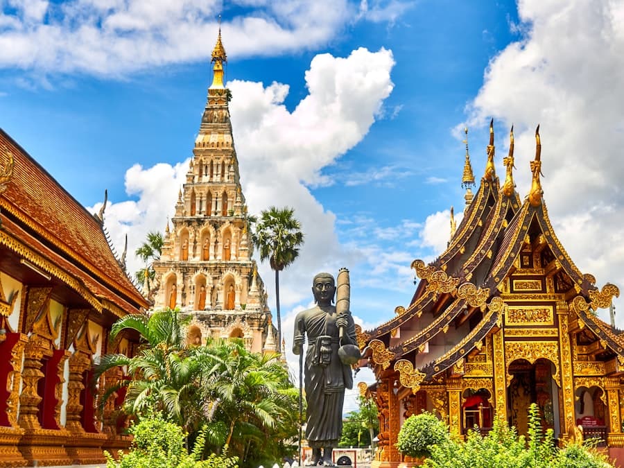 Gilded Lanna temple roofs and a brick chedi in Chiang Mai